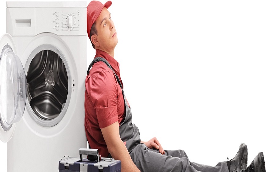 Exhausted plumber sitting by a washing machine